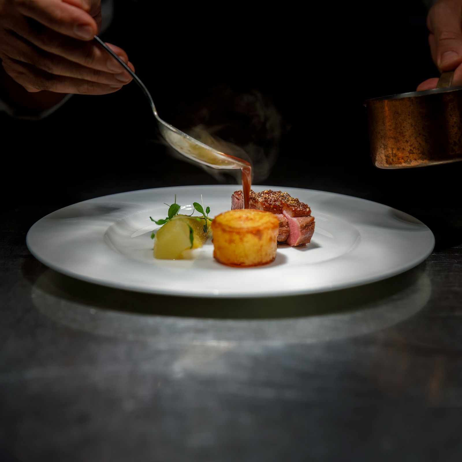 Le chef nappe de sauce une assiette dressée